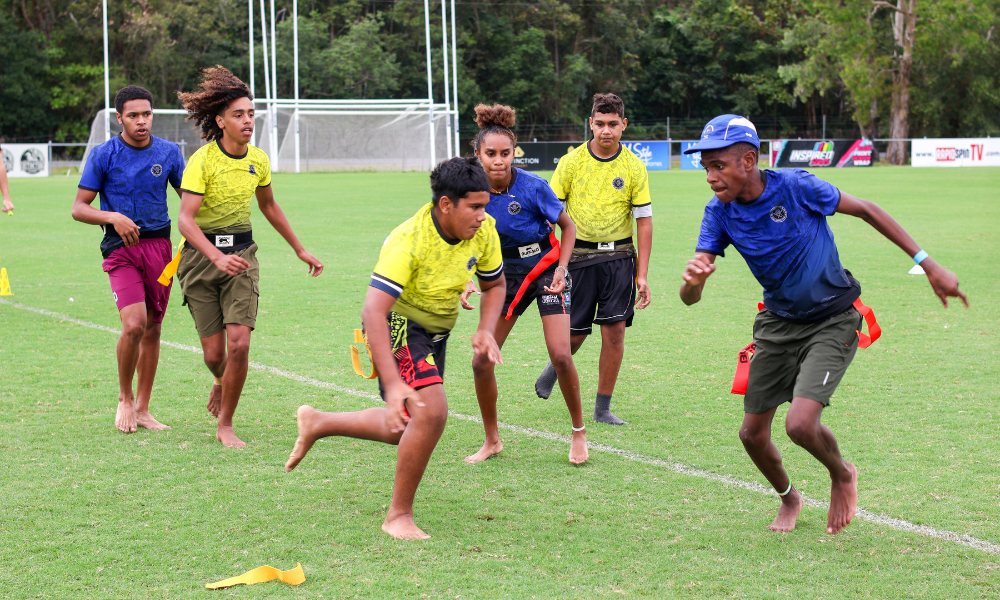 a group of mixed-age people play Edor, a traditional indigenous game of Australia
